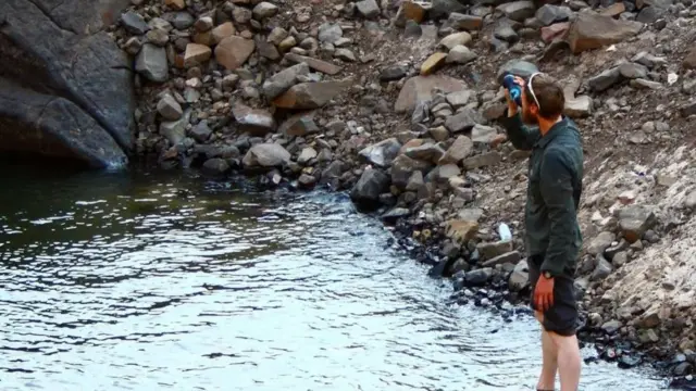 Chaz Powell refrescándose en un río.