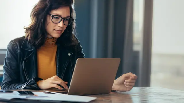 Mulher olha para computador