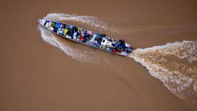 Imagem aérea mostra barco carregadocasa de aposta dando dinheiro no cadastrobarris e pessoascasa de aposta dando dinheiro no cadastroágua marrom do rio