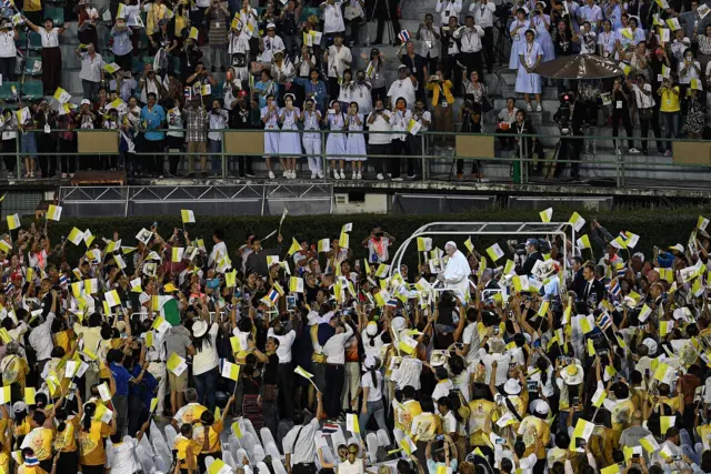 โป๊ปบนรถเปิดหลังคา ท่ามกลางคนมาเฝ้ารับเสด็จฯ ในพิธีมิสซาที่สนามศุภชลาศัย