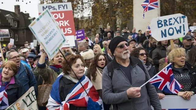 Manifestantes frente al Parlamento en Londres con pancartas que dicen "Brexit ahora"