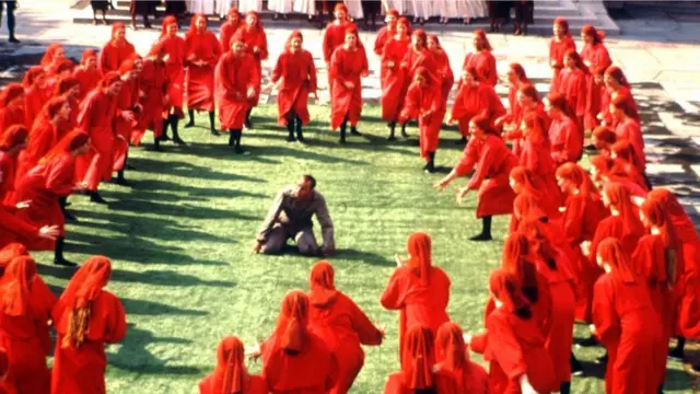 مشهد تمثيلي لشخص يعاني على يد آخرين يحيطون به