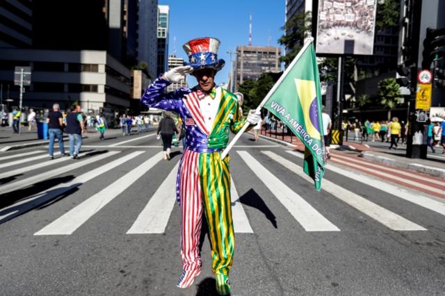 Manifestante na Avenida Paulista, vestindo um traje com uma mescla dos símbolos do Brasil e dos Estados Unidos