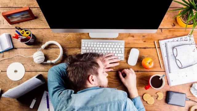 Una persona que se queda dormida sobre su escritorio
