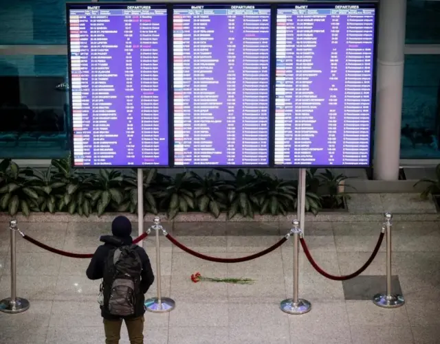 Цветы у табло с расписанием рейсов в Домодедово