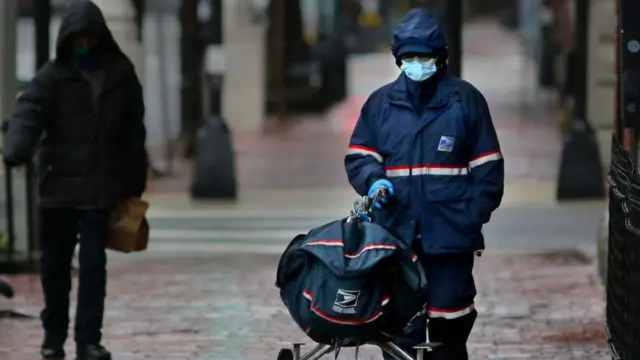 عامل بريد يرتدي الكمامة في أبريل عام 2020