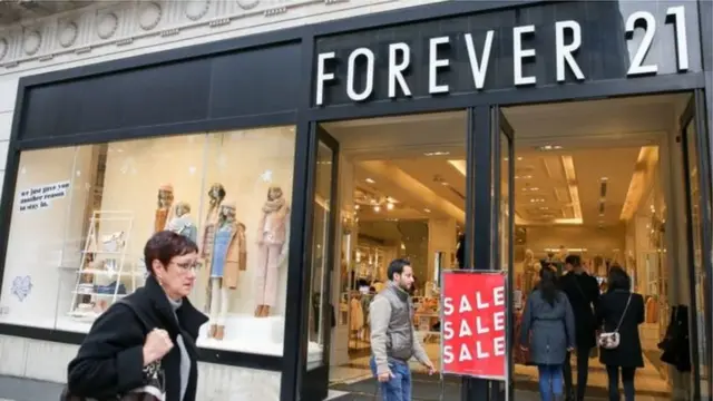 Mulher passa em frente de loja da Forever 21