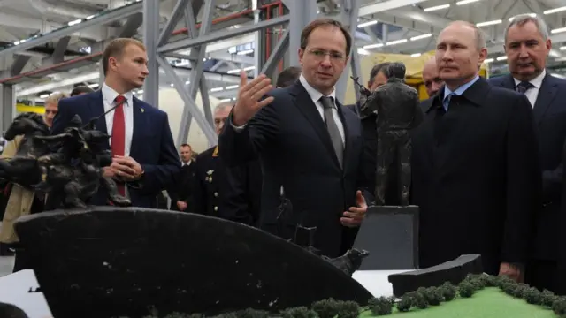 Владимир Путин смотрит на можель памятника.