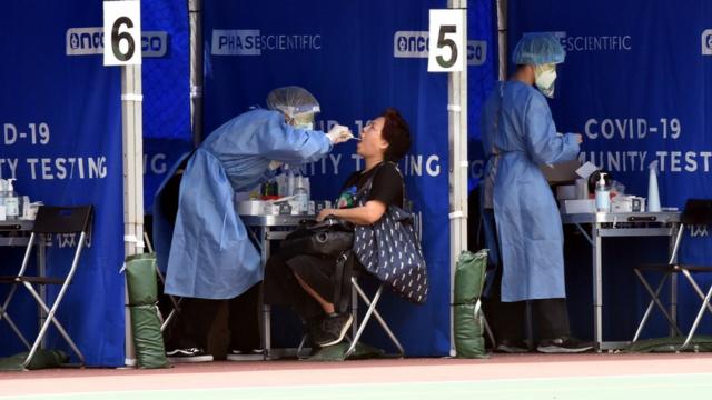 香港九龙长沙湾一处流动采样站市民接受新冠病毒病检测采样（新华社图片12/4/2022）