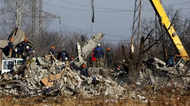Des ouvriers enlèvent les débris d'un bâtiment détruit censé être un collège professionnel utilisé comme hébergement temporaire pour les soldats russes, dont 63 ont été tués dans un tir de missile ukrainien.