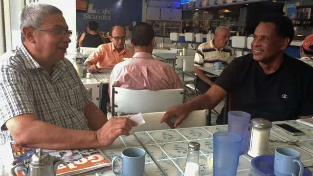 Hombres conversan en tertulia en el café del Gran Hotel Sula