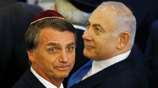 Jair Bolsonaro e Benjamin Netanyahu olham para direções opostas, com sorrisos tímidos, durante evento no Riopixbet portugalJaneiro