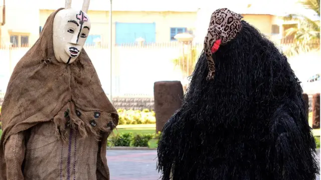 Des personnes vêtues de masques typiques accueillent les invités lors de la cérémonie d'ouverture et d'inauguration du nouveau musée des civilisations noires, à Dakar,