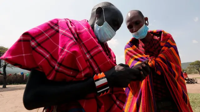 Des masaï utilisant un téléphone portable sur leur propriété dans l'Orboma Manyatta à Sekenani, près de la réserve naturelle de Maasai Mara dans le comté de Narok
