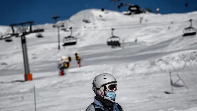 Pemain ski dengan masker di lereng salju di Prancis