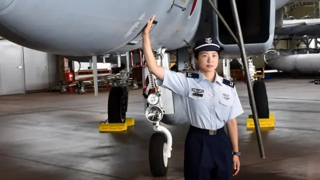 First Lieutenant Misa Matsushima of the Japan Air Self Defence Force poses beside an F-15J air superiority fighter