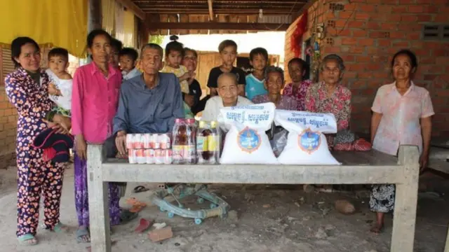 Bun Sen sentadaesporte da sorte 1winfrente a mesa com irmãos, rodeados por outros parentesesporte da sorte 1winvarandaesporte da sorte 1wincasa