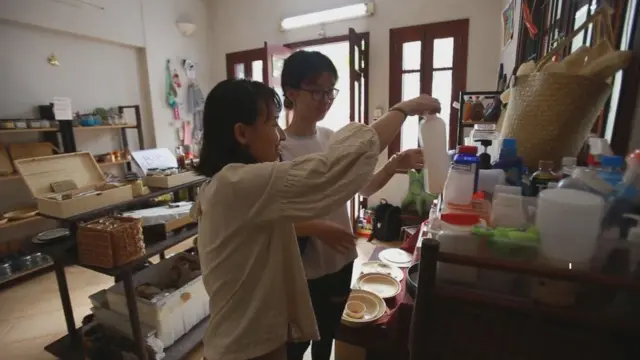 Thao Hoang speaks to a customer in her shop.