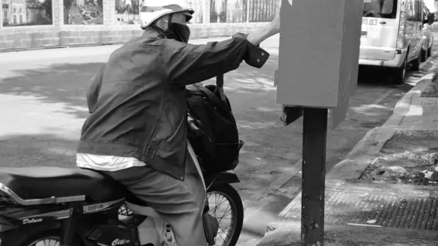 Một cụ già ngoài 70 vội gửi nhanh một lá thư vào thùng.