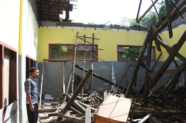 Penjaga sekolah berada di ruang kelas yang rusak di Desa Selodakon, Tanggul, Jember, Jawa Timur, Kamis (06/02/2020). Sebanyak 145 siswa yakni kelas satu sampai kelas enam terpaksa berbagi ruangan kelas dengan kelas lainnya karena ruang kelas empat, lima dan enam rusak berat dan belum ada perbaikan