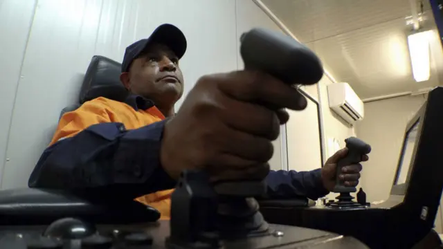 奇瓦（Leslie Kewa）坐在有空調的船艙內