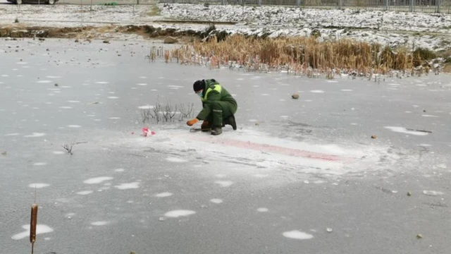 Коммунальщик рубит под собой лед топором