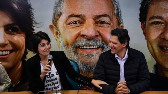 Manoela D'Ávila e Fernandon Haddad com fotobolão online loteriaLula ao fundo