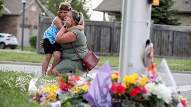 Una niña abraza a una mujer cerca de un tributo a la familia asesinada en Ontario, Canadá.