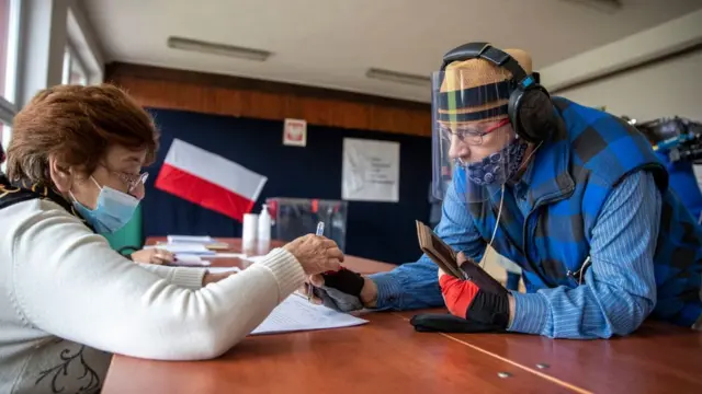 An elderly voter arrives to cast his ballot during Poland's Presidential elections