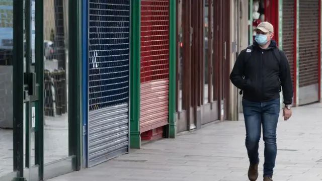 Homem caminhandoroleta demo gratisNova York, com comércio fechado