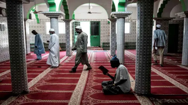 Musulmai a masallaci sun kama wajen yin sallah tare da bin dokar ba da tazara tsakani bayan sake bude ,masallatai a karon farko cikin wata biyu a ranar 12 ga watan Mayu 2020. - Wannan na zuwa ne bayan shugaban kasar Senegal, Macky Sall, ya sanar da sassauta dokar hana fita ta korona ta hanyar buɗe kasuwa sau 6 a mako dare da wuraren bauta.