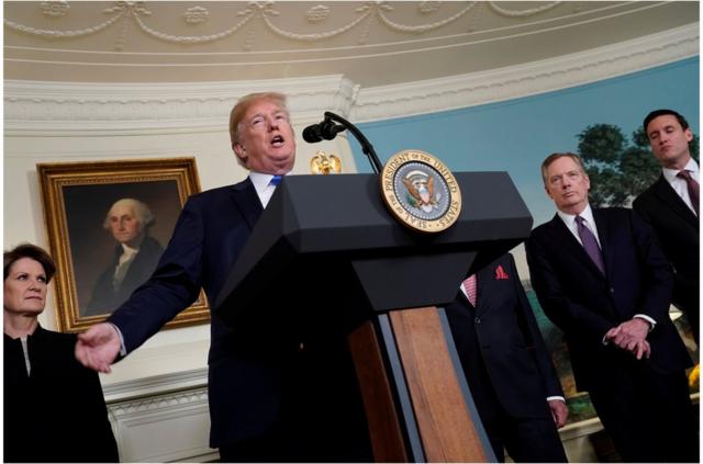 U.S. President Donald Trump, flanked by Lockheed Martin CEO Marillyn Hewson, U.S. Trade Representative Robert Lighthizer and White House Homeland Security Advisor Tom Bossert, delivers remarks before signing a memorandum on intellectual property tariffs on high-tech goods from China, at the White House in Washington, U.S. March 22, 2018. REUTERS/Jonathan Ernst