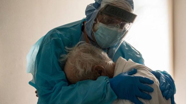 Médico abraça e conforta um paciente com covid-19 na UTI