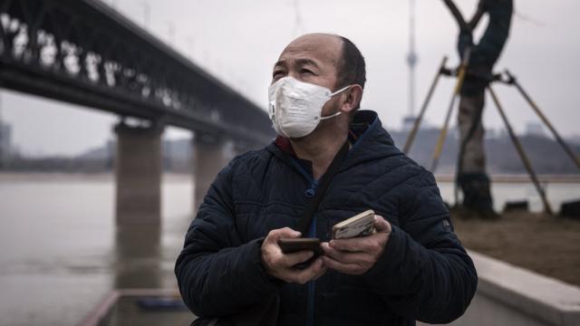 FEBRUARY 11: A man wears a protective mask as he stands under the Yangtze River Bridge