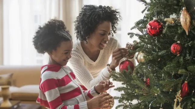 Photo of a mother and daughter near a Christmas tree