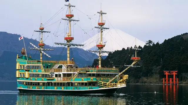 Replika kapal bajak laut Jepang dengan latar belakang Gunung Fuji.