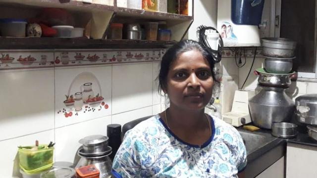 Shanthi debout dans sa cuisine