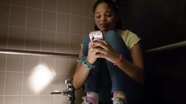 Una niña usa su teléfono para contactar con su madre en medio de un tiroteo en su escuela.