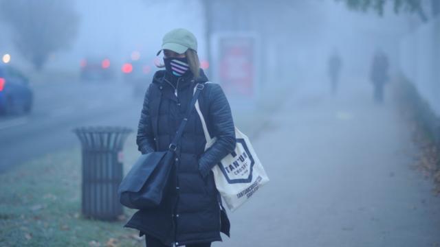 Mujer caminando en una calle contaminada en Sarajevo
