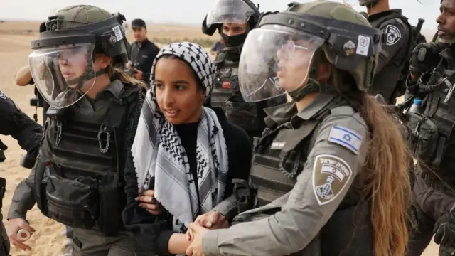 الشرطة الإسرائيلية تعتقل شابة أثناء احتجاج البدو في صحراء النقب، في 12 يناير/كانون الثاني 2022