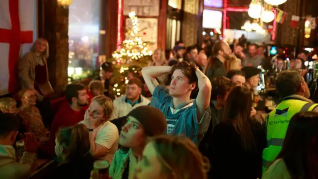 Люди смотрят 1/4 финала в лондонском пабе