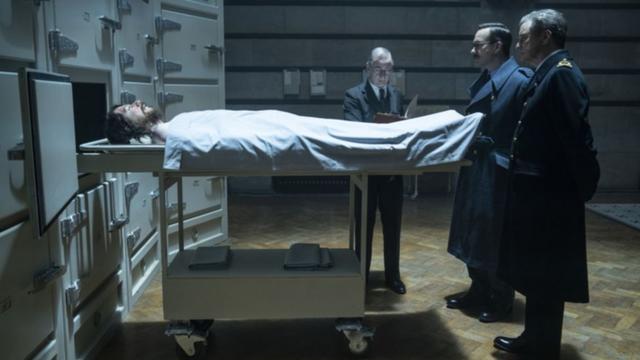 Cena do filme Operation Mincemeat. Agentes britânicos são vistostalvitie pokerfrente aos restos mortaistalvitie pokerMichael