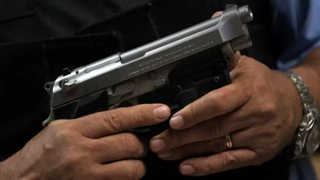 Una mano sosteniendo un arma