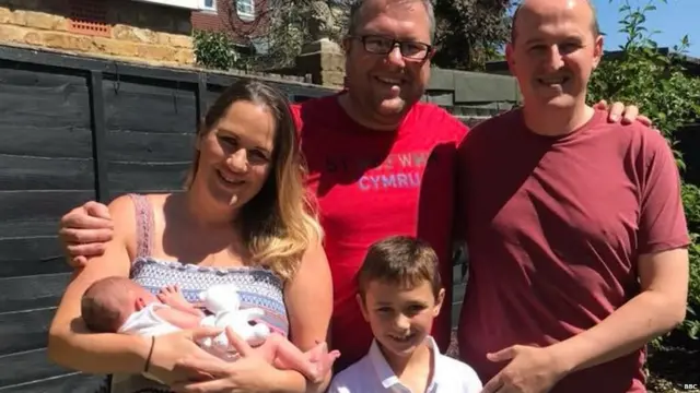 Robyn holding her son Teddy. She's standing next to her brother Gareth and his son, with her husband far right