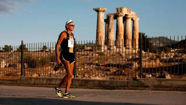 أحد العدائين المشاركين في ماراثون إسبرطة 2013 يتقدم بهدوء متجاوزا أحد معابد كورنثوس القديمة