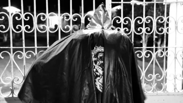 Animero frente a las puertas del cementerio.