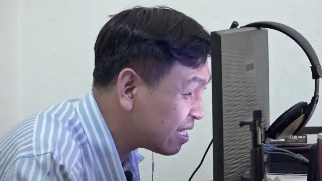 นายจตุพล หนูท่าทอง เอาหน้าชิดจอคอมพิวเตอร์เพื่อเตรียมวิดีโอประกอบการไลฟ์