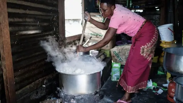 A woman prepares Ugali, a typical local food made of maize flour, on Migingo island on October 5, 2018 which is densely populated by residents fishing mainly for Nile perch in Lake Victoria on the border of Uganda and Kenya