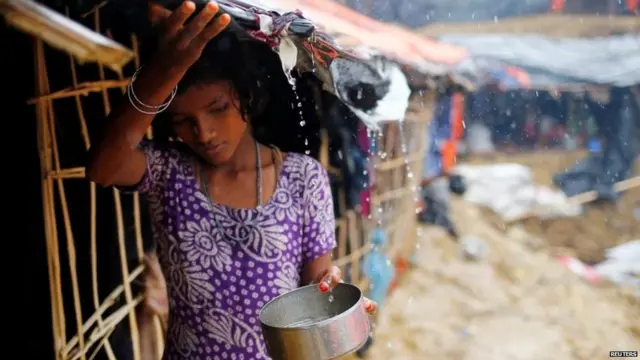 A Rohingya refugee girl collects rain water at a makeshift camp in Cox"s Bazar, Bangladesh.