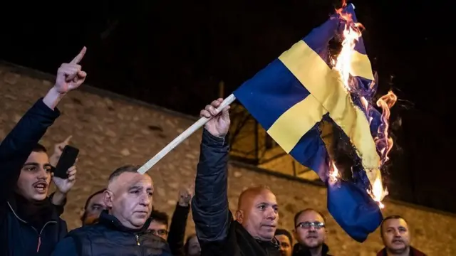 स्वीडन के कांसुलेट जनरल के सामने प्रदर्शनकारियों ने स्वीडन के झंडे को आग के हवाले किया
